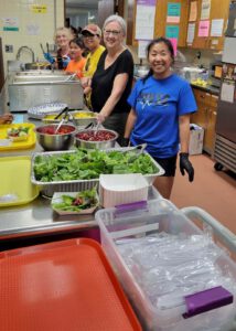Group of smiling volunteers in the Food at First kitchen